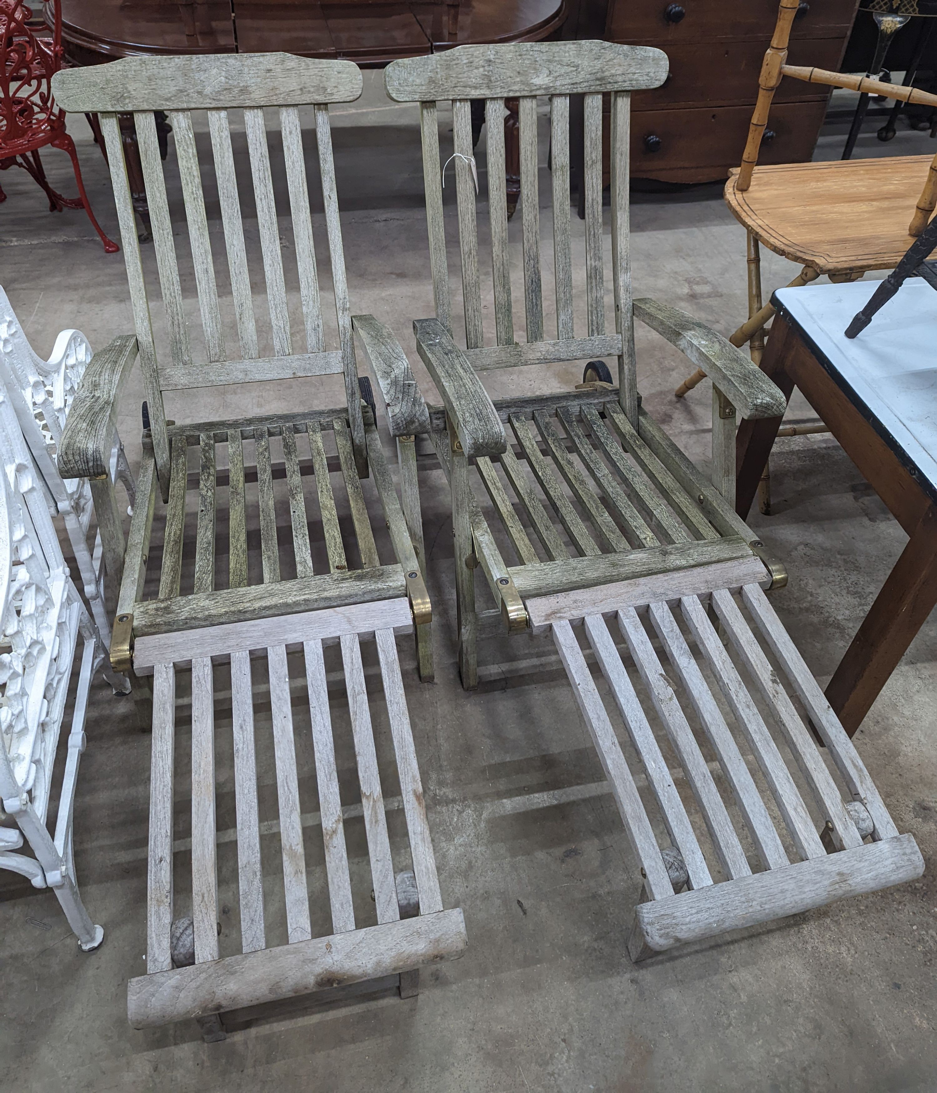 A pair of slatted weathered teak garden steamer chairs, width 59cm, height 97cm